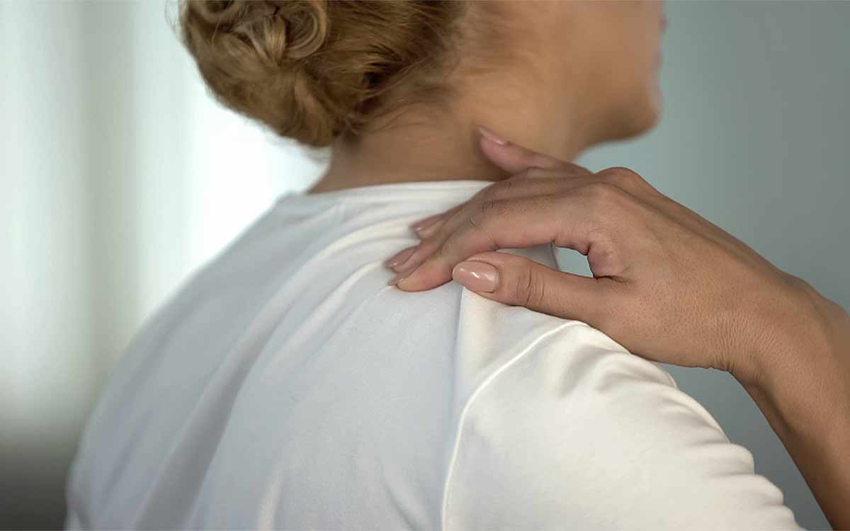 Woman with hand on her neck wondering if she should get surgery for her pinched nerve.