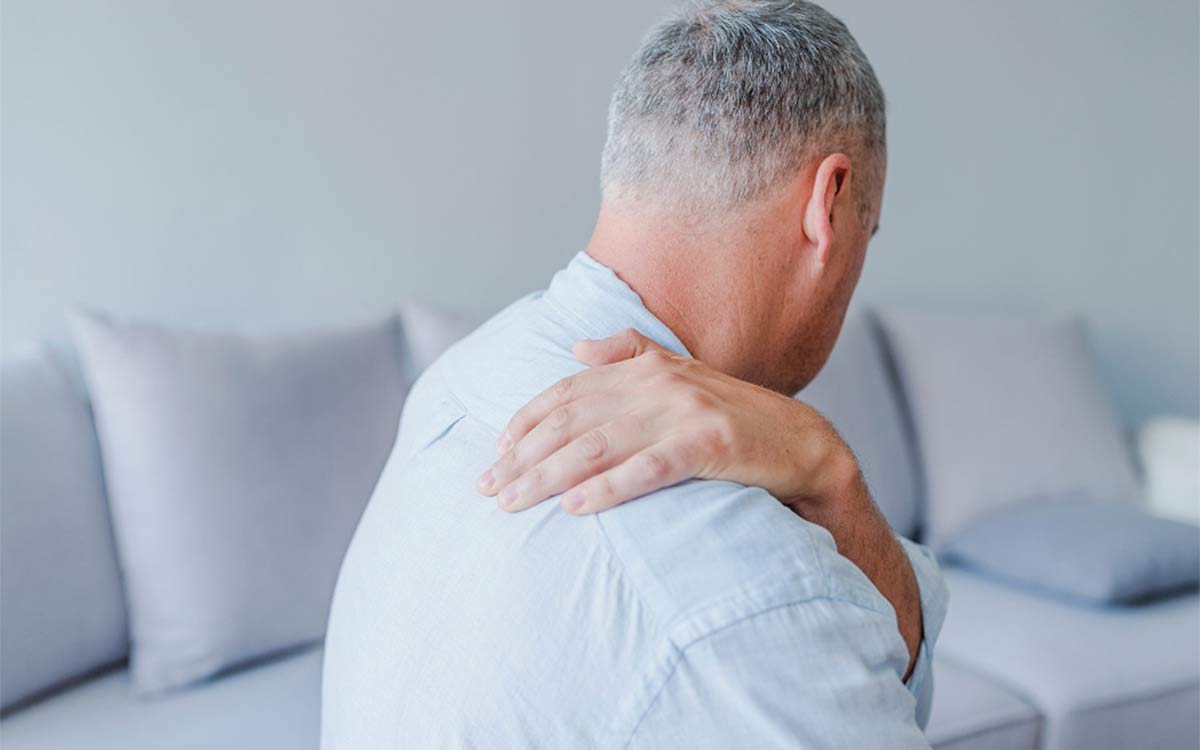 Man suffering from shoulder pain who needs winged scapula surgery.